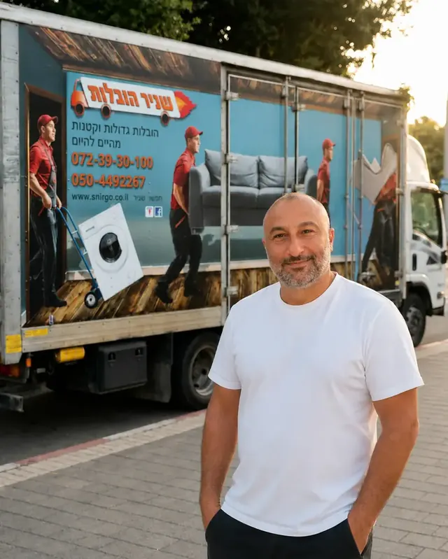 שניר הבעלים עומד ליד משאית ההובלה הממותגת של שניר הובלות